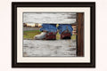 Framed  coloured pencil artwork of cowboy boots on a wooden fence.